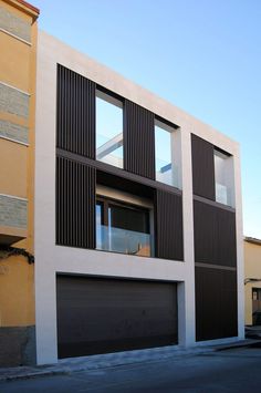 an apartment building with two garages on the street