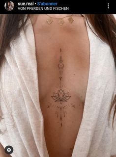 the back of a woman's breast with tattoos on her chest and an arrow