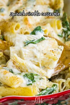 spinach rotini casserole in a red dish with a wooden spoon