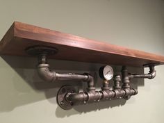 pipes and gauges are attached to the wall above a shelf in a room with white walls