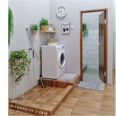 a washer and dryer in a room with wood flooring on the side