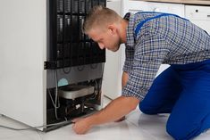 a man fixing an air conditioner on the floor