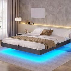 a large bed with blue lights on the sides and headboard is in a bedroom