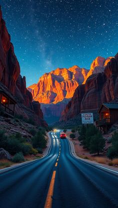 a car driving down the road in front of mountains at night with stars above it