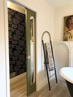 a bath tub sitting next to a wall with writing on the walls and a ladder in front of it