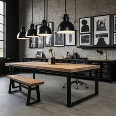 an industrial style dining room with black and white decor, wooden table, hanging lights, and framed pictures on the wall