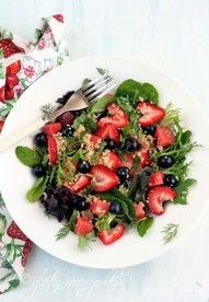 a white plate topped with salad and berries