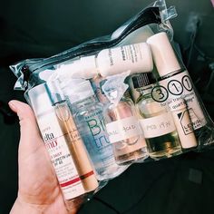 a person holding a clear bag filled with cosmetics