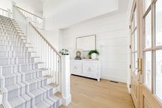 a white staircase in a house with wood floors