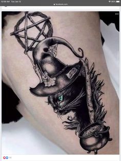 a black cat with a witches hat on it's thigh