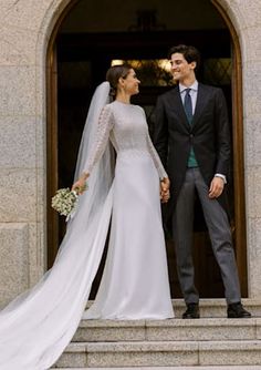 a bride and groom are standing on the steps