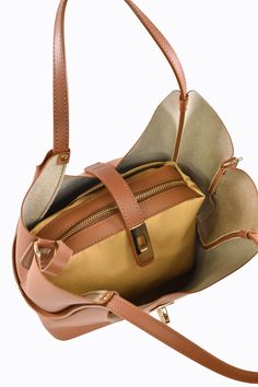 Borsa Amelie in vera pelle Spazzolata con tracolla Made in Italy e accessori color oro chiaro La parte interna è composta da un grande scomparto principale con all'interno una Pochette Estraibile con una tasca con chiusura a Zip. -Materiale esterno: Vera pelle Spazzolata -Materiale hardware: Acciaio inossidabile color oro chiaro -Materiale interno: Vera pelle di vitello lavorata -Materiale etichetta Voemièn interna: Vera pelle -Materiale manico: Vera pelle Spazzolata -Chiusura: Incastro -Confezi On-the-go Bag With Zipper Pocket And Pouch Shape, Versatile Leather Box Bag With Zipper, Elegant Cognac Bucket Bag For On-the-go, On-the-go Box Bag Shoulder Shape, Daily Use Satchel Bag With Zipper Pocket, Leather Backpack With Gold-tone Hardware For On-the-go, Leather Tote Bag With Zipper Closure, Versatile Cognac Shoulder Bag With Detachable Strap, Daily Use Satchel Shoulder Bag With Zipper Pocket