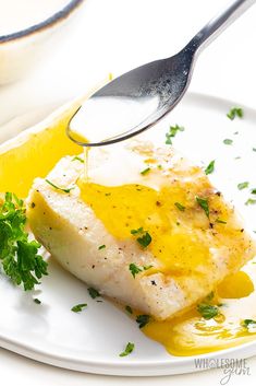 a white plate topped with fish covered in sauce