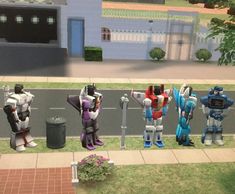 four robots are lined up in front of a building on the side of a road