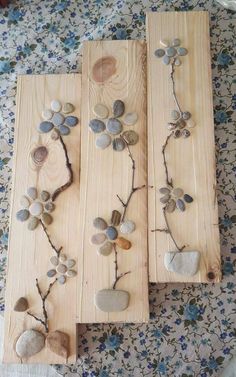 three wooden planks with stones and leaves on them