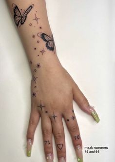 a woman's hand with butterflies and stars on it