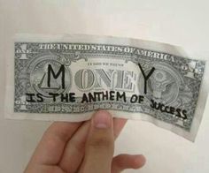 someone holding up a money bill with the words money is the antem of success