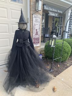 a black dress and hat on display in front of a building