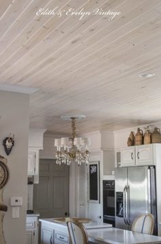 a kitchen with white cabinets and wooden ceilings