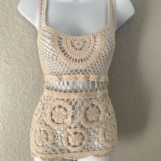 a white mannequin wearing a crochet top