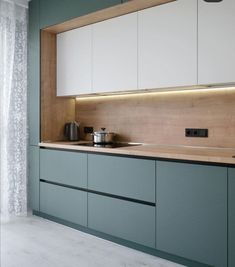 a kitchen with green cabinets and white cupboards on the wall, along with a teal counter top