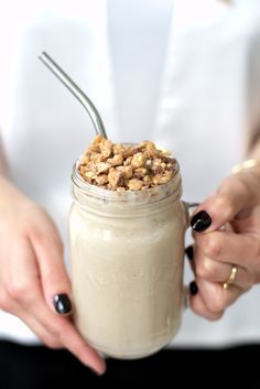 a woman holding a mason jar filled with oatmeal