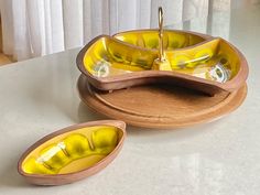 two wooden bowls sitting on top of a counter next to each other, one yellow and the other brown