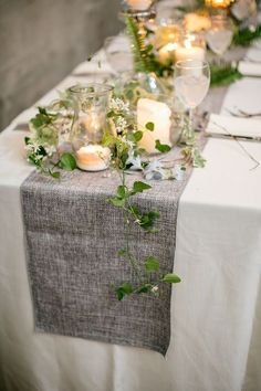 the table is set with candles and greenery