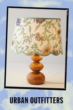 a lamp shade sitting on top of a wooden table next to a blue and white background