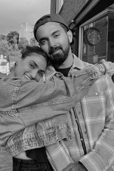 a man and woman hugging each other on the street