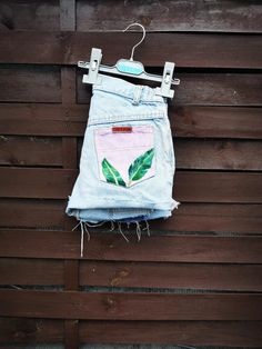 a pair of jeans hanging on a wooden wall