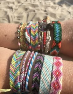 several different bracelets on someone's arm at the beach