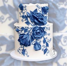 a white and blue wedding cake with flowers on it