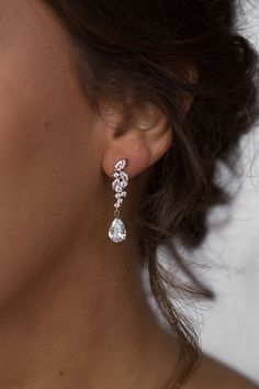 a close up of a person wearing some kind of earring with diamonds on it