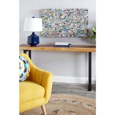 a yellow chair sitting in front of a table with a lamp on top of it