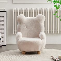 a white teddy bear chair sitting on top of a rug