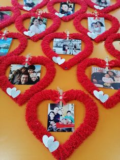 a table topped with lots of red heart shaped frames filled with photos and hearts attached to them