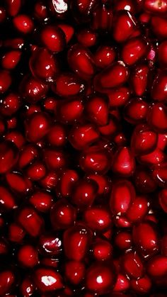 close up view of pomegranates in a bowl with red liquid on it