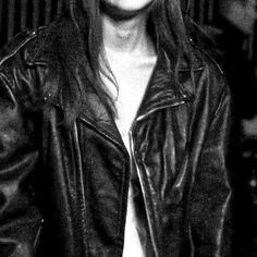 a black and white photo of a woman wearing a leather jacket