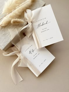 the wedding stationery is wrapped in white paper and tied with a light brown ribbon