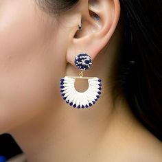 a close up of a person wearing earring with an ear pin in the shape of a circle