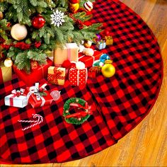 a christmas tree with presents under it on a red and black checkered tablecloth