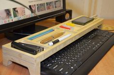 a computer desk with a keyboard, mouse and cell phone