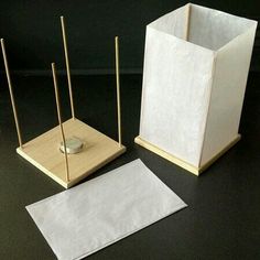 two small white vases sitting next to each other on top of a black table