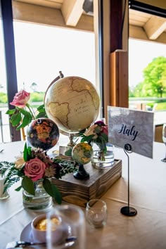 a table topped with a globe and flowers