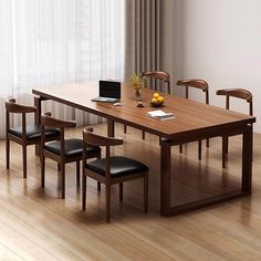 a wooden table with four chairs and a laptop on it in front of a window