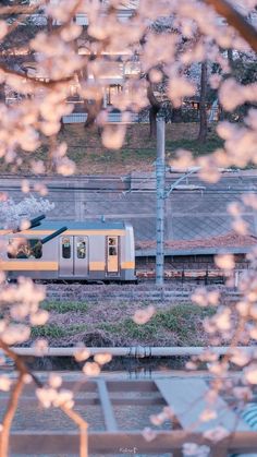 a train traveling down tracks next to a lush green field