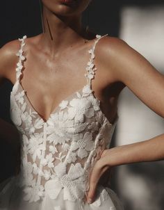 a woman wearing a white dress with flowers on it