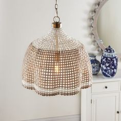 a light fixture hanging from a ceiling in a room with white walls and blue vases