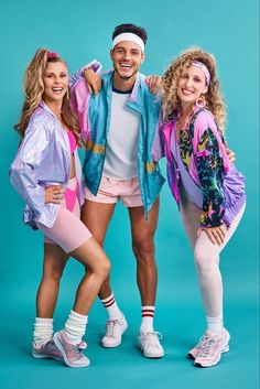 three people are posing for a photo in front of a blue background wearing colorful clothing and headbands